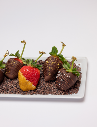 Tray of chocolate dipped strawberries with a variety of garnishes