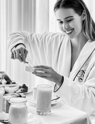 Woman scooping out of a dish with a full breakfast food filled tray