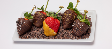 Tray of chocolate dipped strawberries with a variety of garnishes
