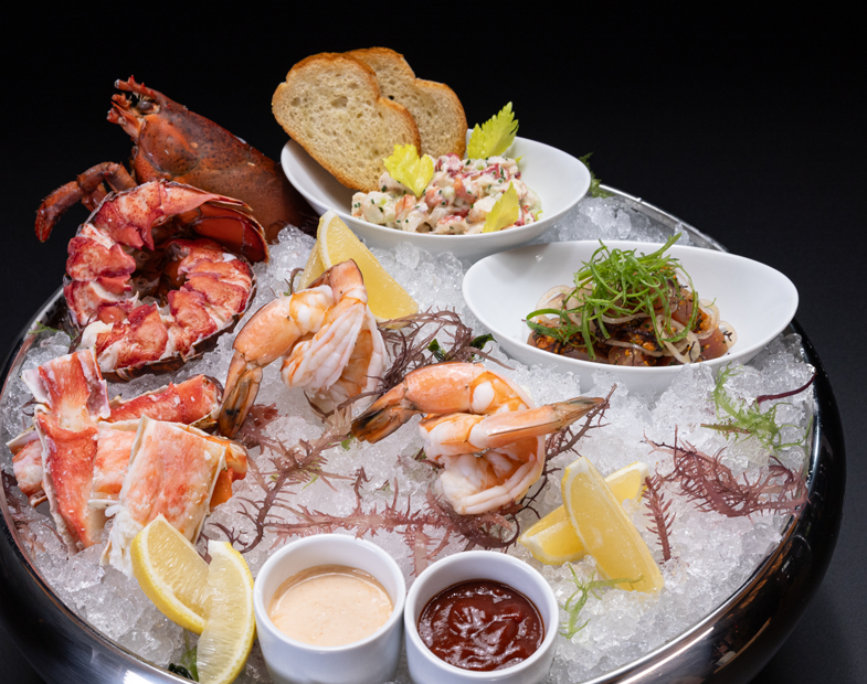 Bowl of a variety of seafoods, garnishes and bread