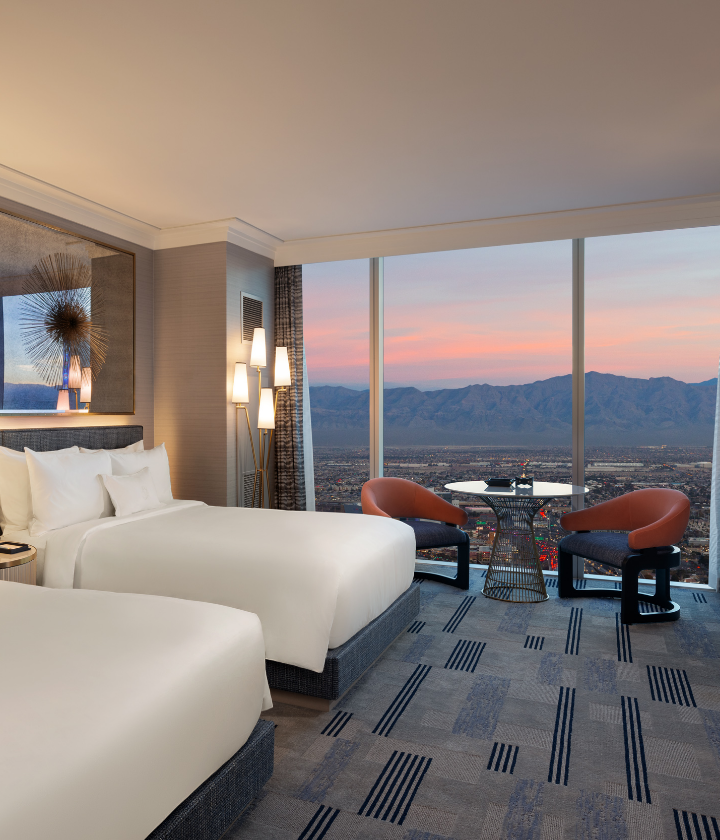 2 beds with lamps, table and chairs, with mountain vista