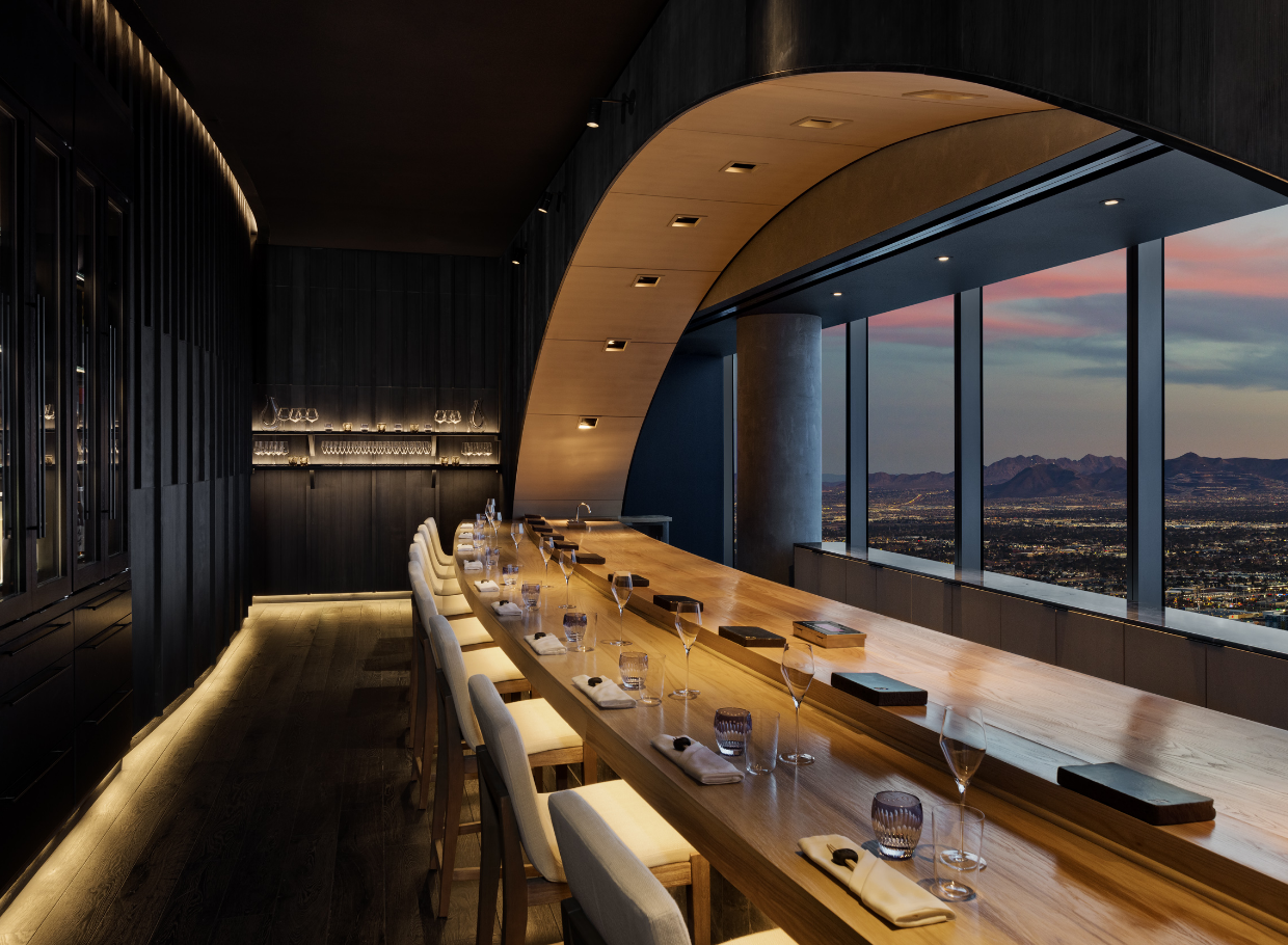 Seating with table settings and mountain view under arched lighting feature