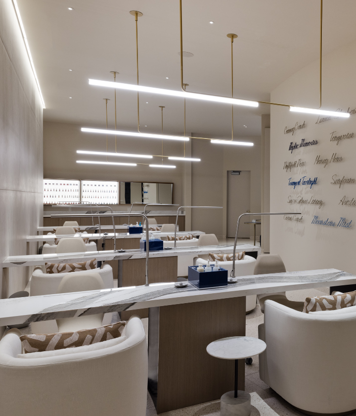 Rows of nail stations with artistic text on the wall