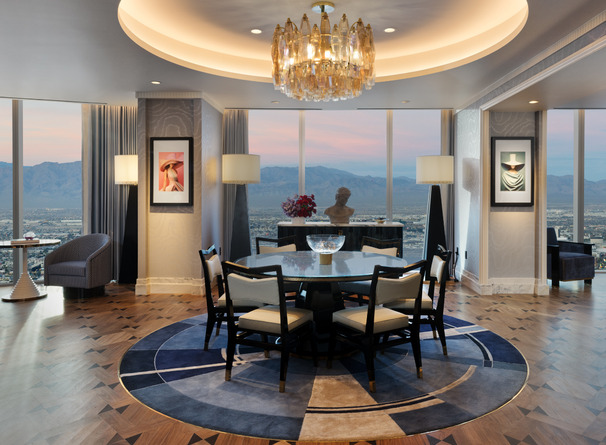 Circular table under a chandelier in front of a window with a mountain vista