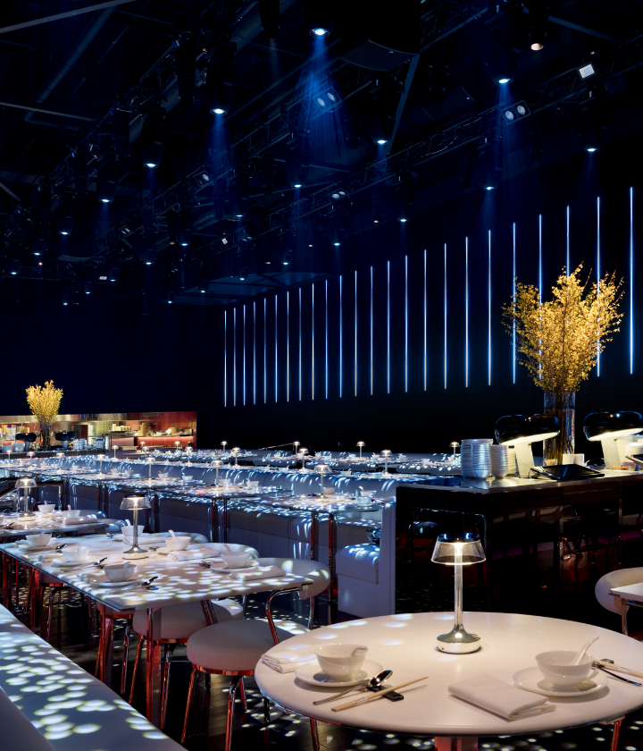 Interior of dining area with tan seats and tables with lighting above