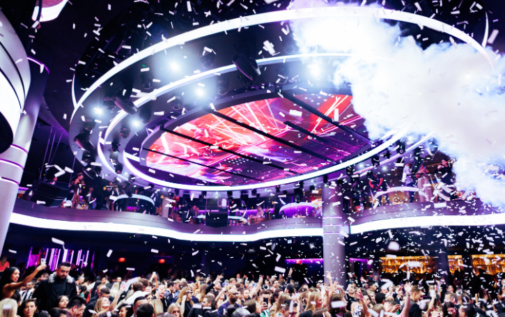LIV night club lit up by white LED with confetti and smoke being shot over excited crowd