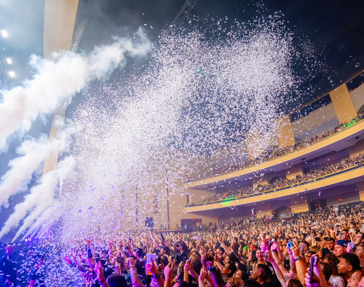 White confetti shooting over 3 story theater crowd
