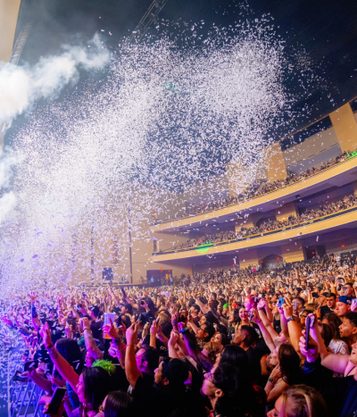 White confetti shooting over 3 story theater crowd