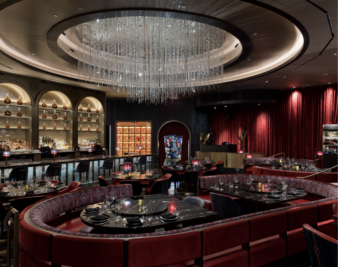 Interior seating booths and bar area under a chandelier