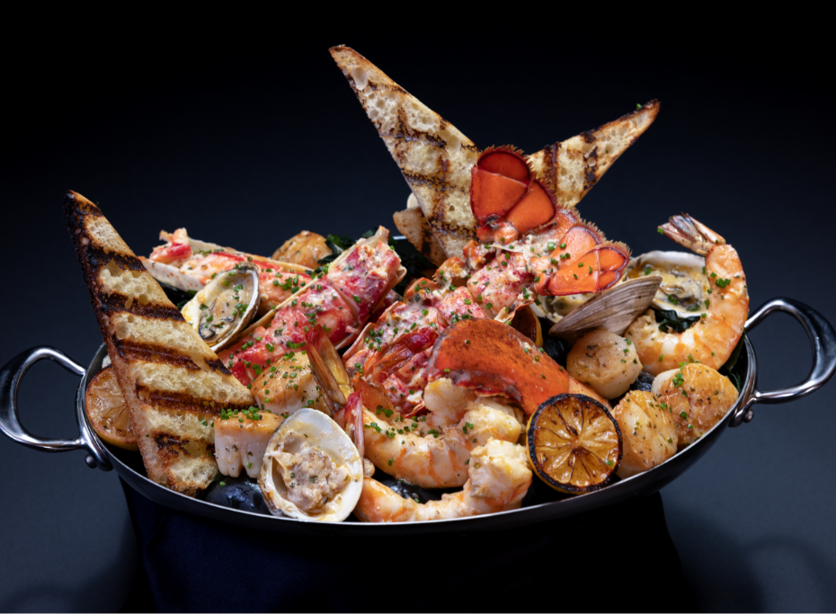 Bowl of a variety of cooked seafood and grilled bread