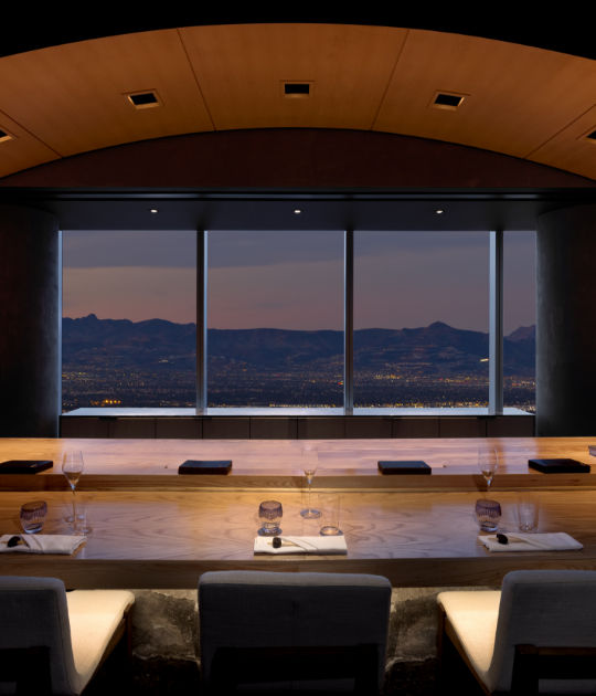 Seating area underneath curved lighting arch looking at a mountain vista