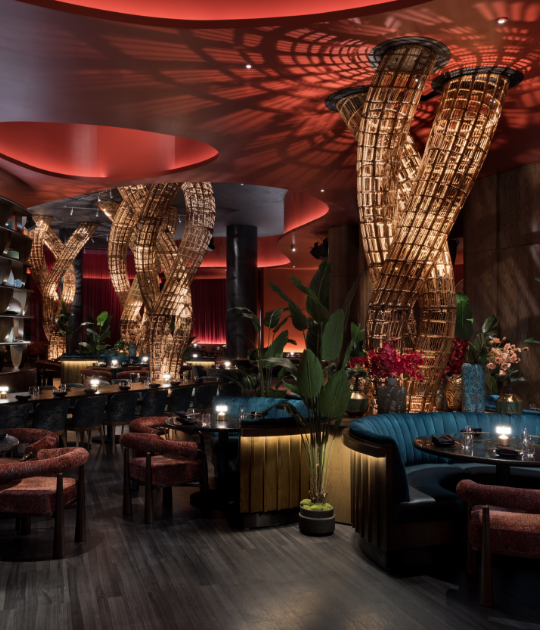 Uplit wire abstract sculpture surrounded by green booths and set tables