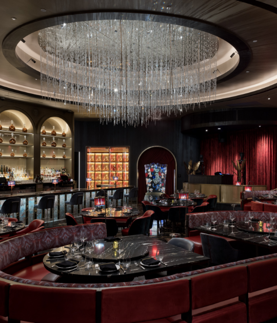 Interior seating booths and bar area under a chandelier