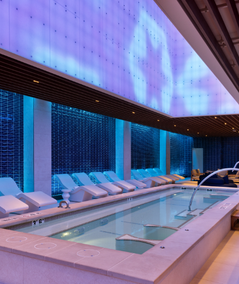 Blue pool room with white lounge chairs