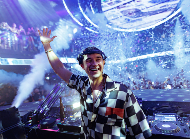 DJ with arm up looking out at the crowd