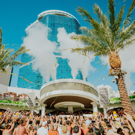 Crowded LIV Beach poolside with smoke and streamers being launched