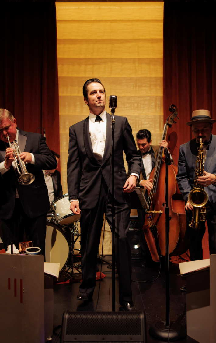 Band with singer, drummer, trumpet, saxophone and cello performing