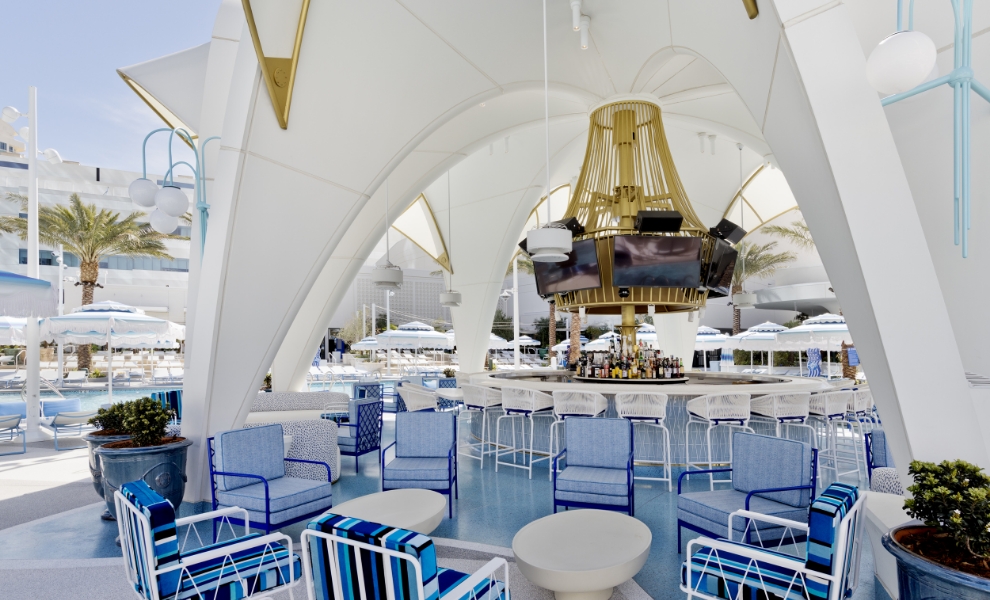 Outdoor pool area with seating and arched architectural over bar