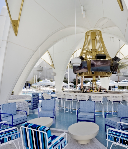 Outdoor pool area with seating and arched architectural over bar