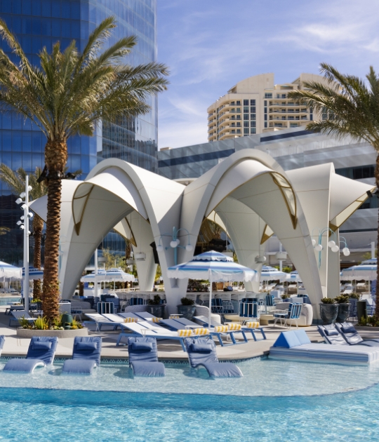 Poolside lounges and chairs with arched architectural detail above Bleau Isle