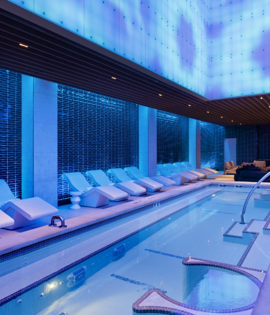 Blue pool room with white lounge chairs