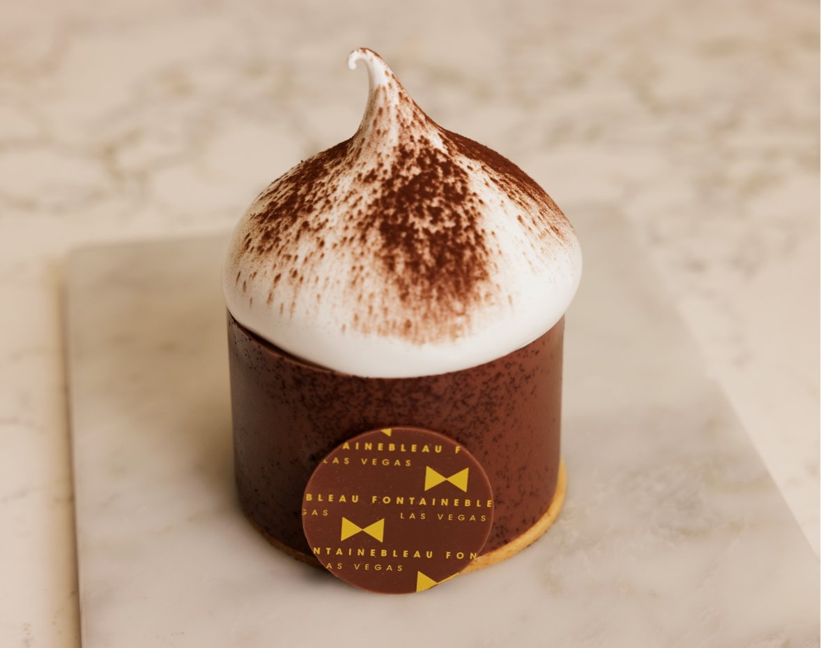 Chocolate dessert with white dollop and sprinkled cocoa