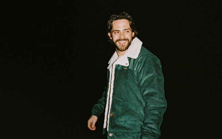 Man in green jacket on dark background
