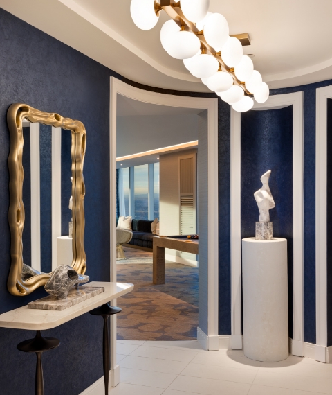 Hallway entry area with art sculpture, mirror, and light fixture