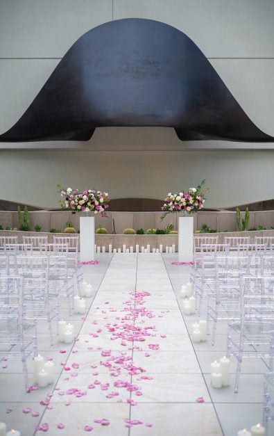 Hat art piece framing a pathway with flower petals and seating.