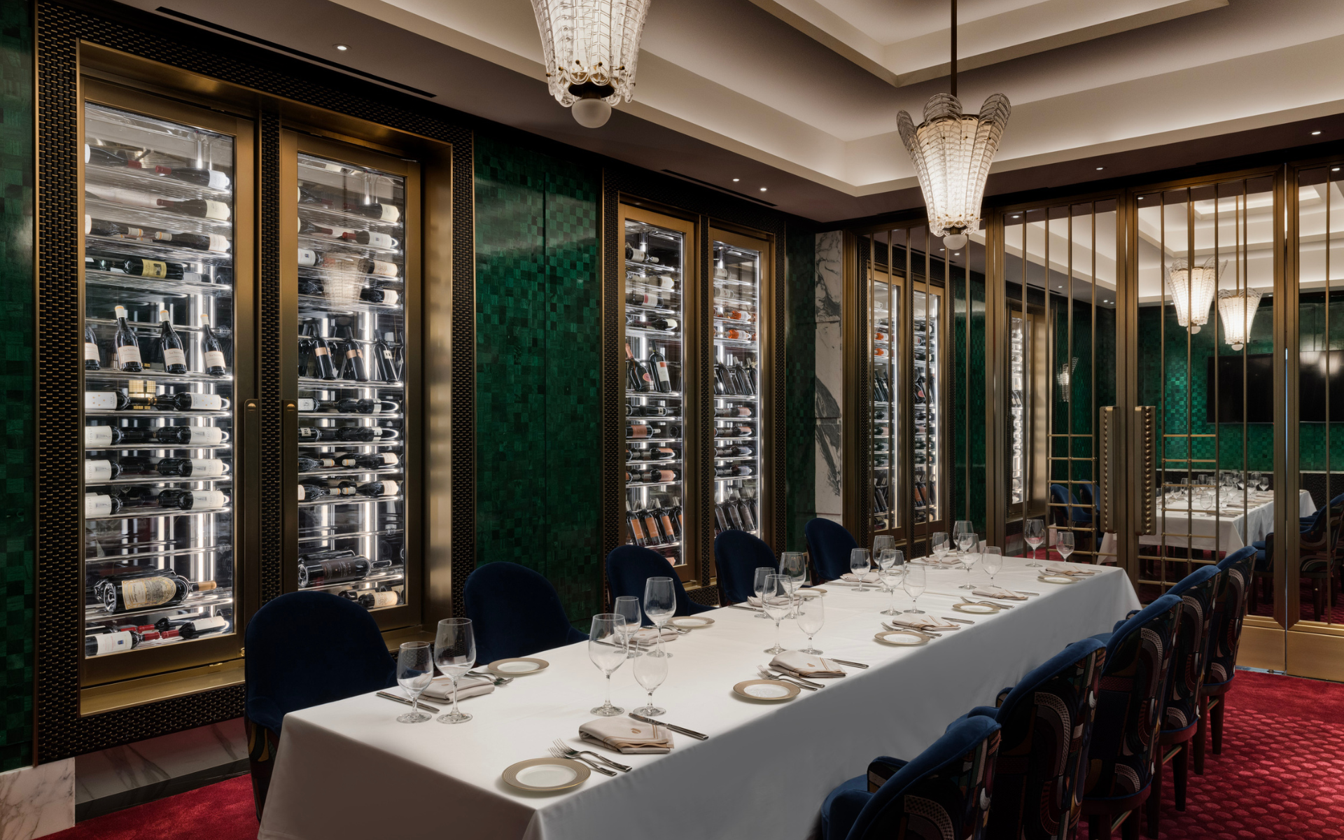 Restaurant dining space with green walls and wine fridge