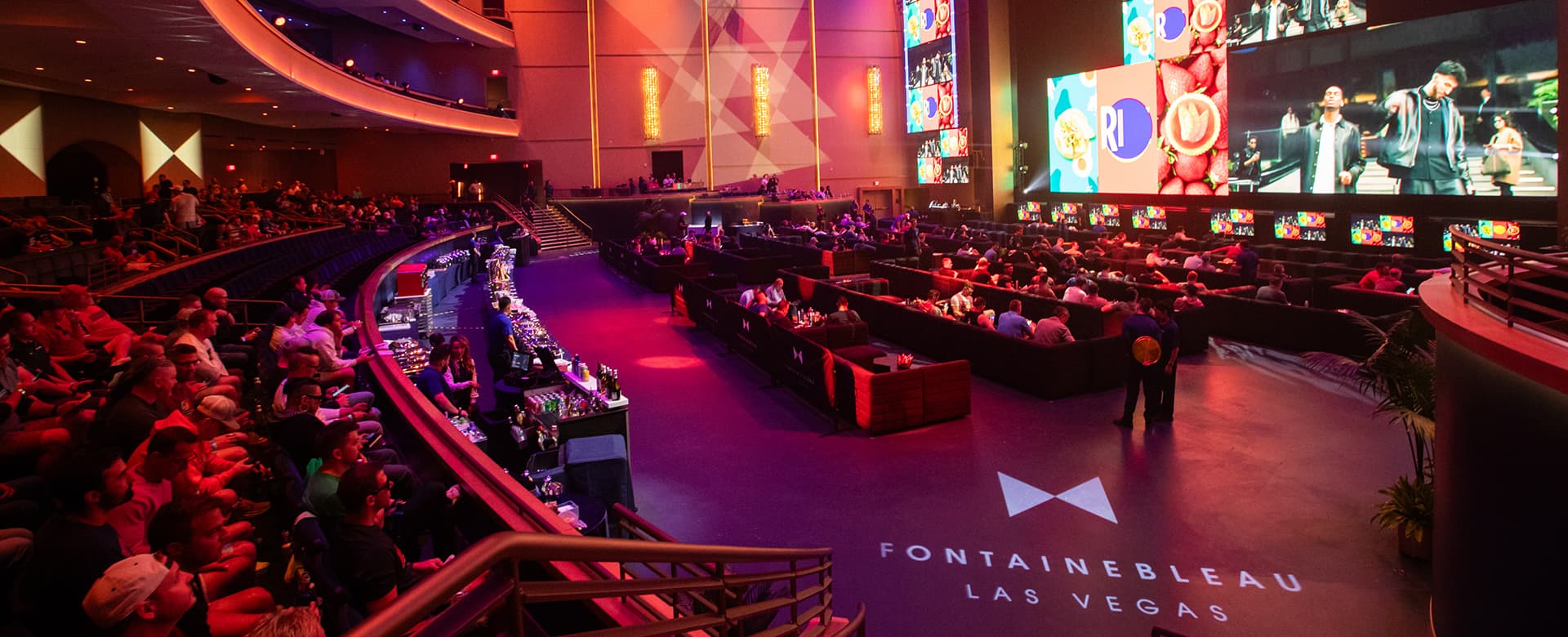 Crowded BleauLive Theater with basketball imagery on screens