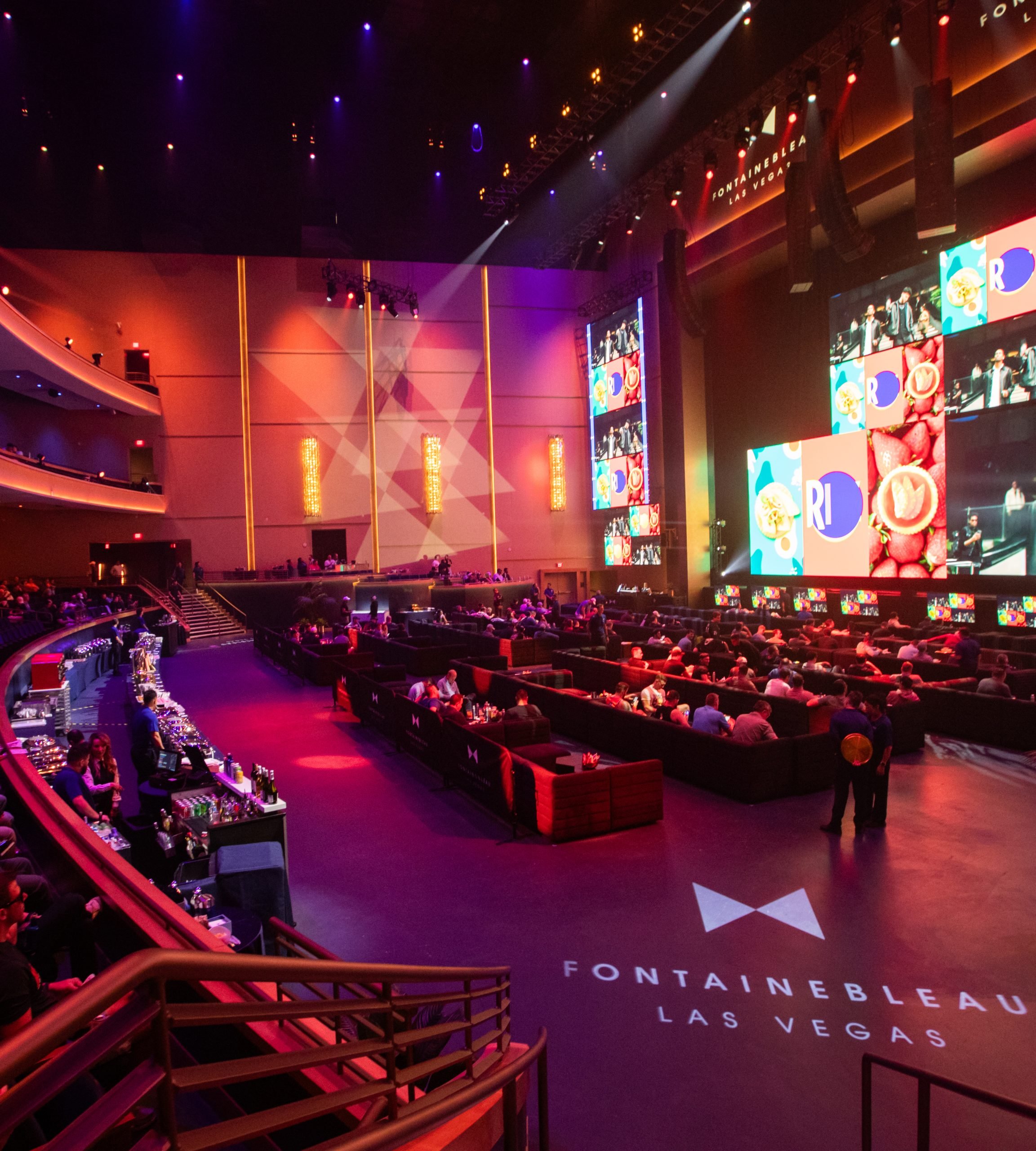 Crowded BleauLive Theater with basketball imagery on screens
