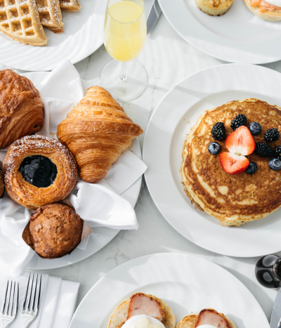 Plates of breakfast food on white background