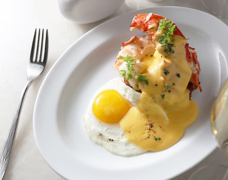 Plate of breakfast food on a white plate next to a silver fork.