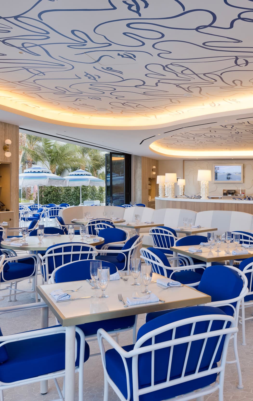 Dining area with blue chairs under a white and blue ceiling