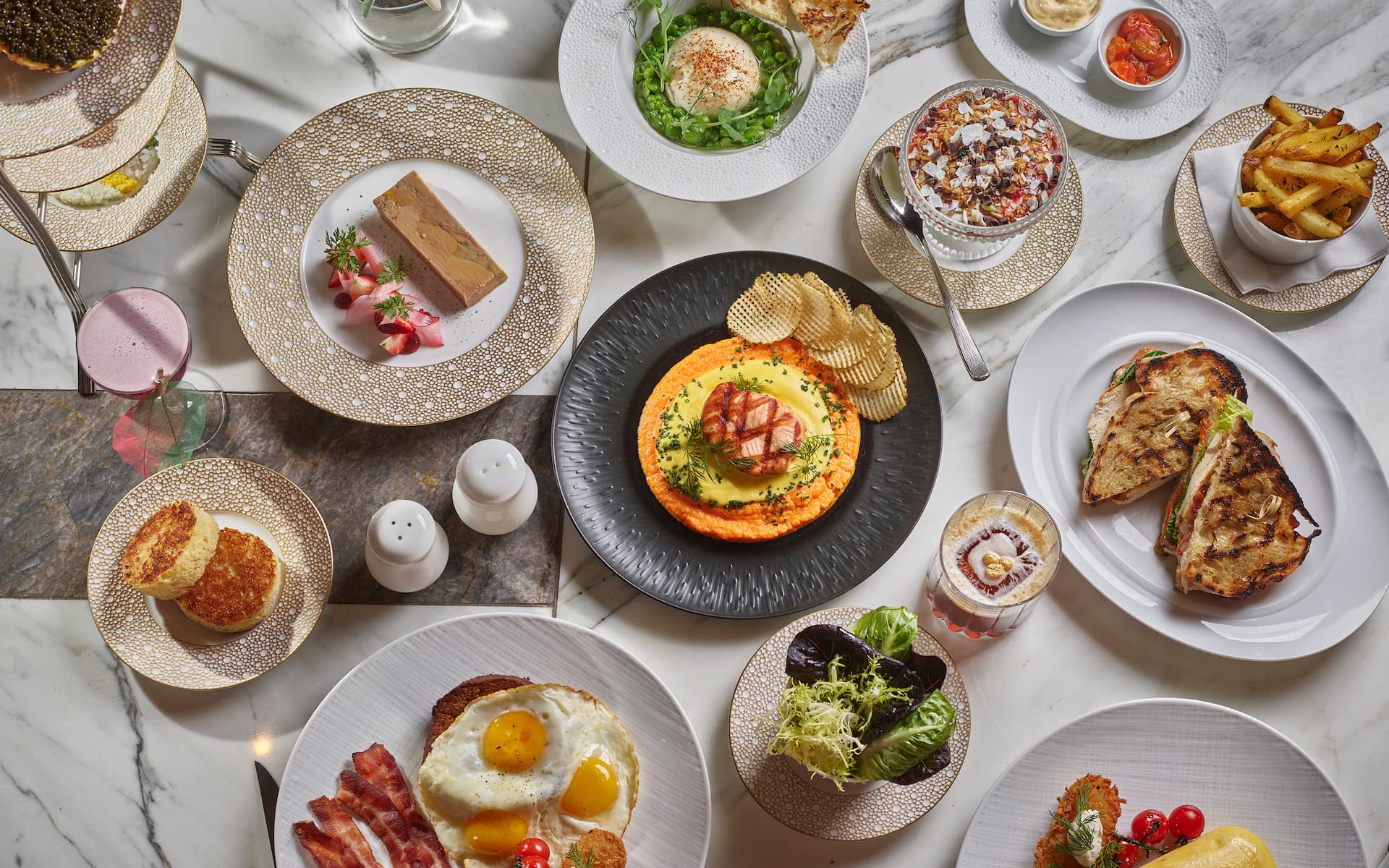 Full table of food against a white marble background