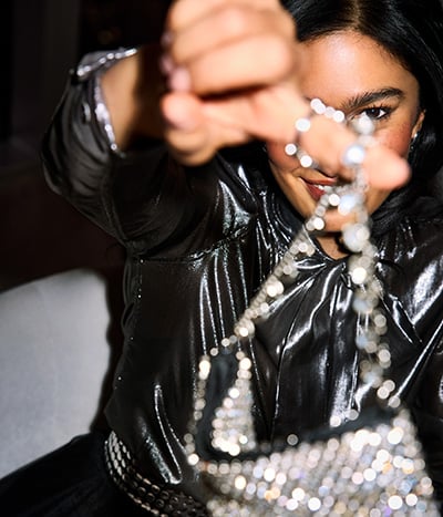 Woman holding a shiny necklace in front of her face in the Poodle Room at Fontainebleau Las Vegas