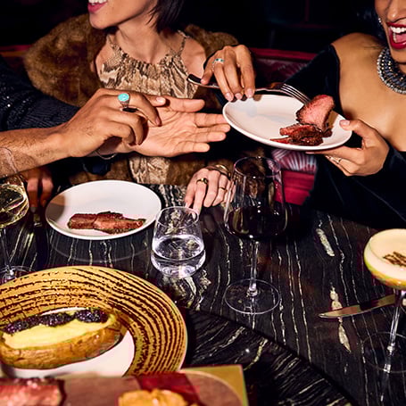 Plates of food being passed around in Papi Steak