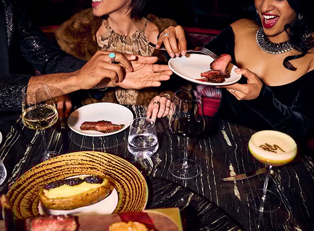 Plates of food being passed around in Papi Steak