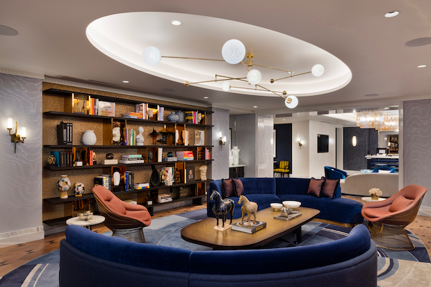 Seating area with bookshelves under lighting fixture in one of the rooms in Fontainebleau Las Vegas