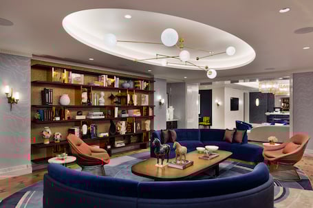 Seating area with bookshelves under lighting fixture in one of the rooms in Fontainebleau Las Vegas