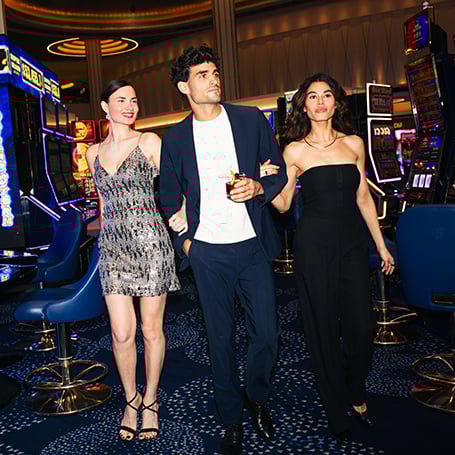 Man walking with two women framing through slot machines at Fontainebleau Las Vegas