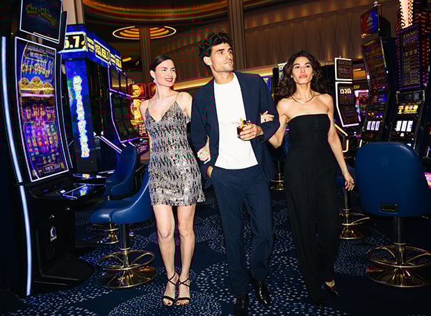 Man walking with two women framing through slot machines at Fontainebleau Las Vegas