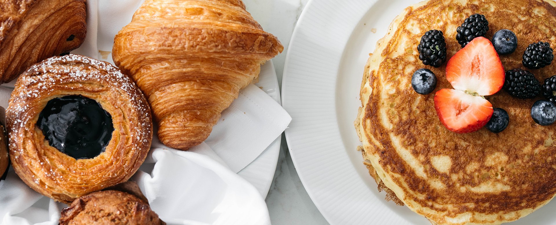 Plates of pancakes, croissant, and pastries for room service at Fontainebleau Las Vegas