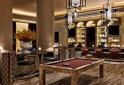 Pool table in front of bar in neutral colors