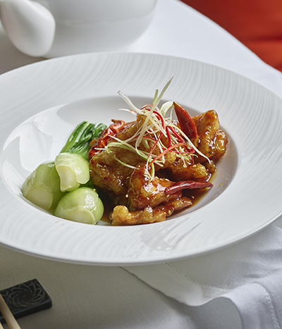 Meat and vegetables on a white plate with rice from Chyna Club restaurant