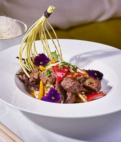 Meat and vegetables on a white plate with rice from Chyna Club restaurant