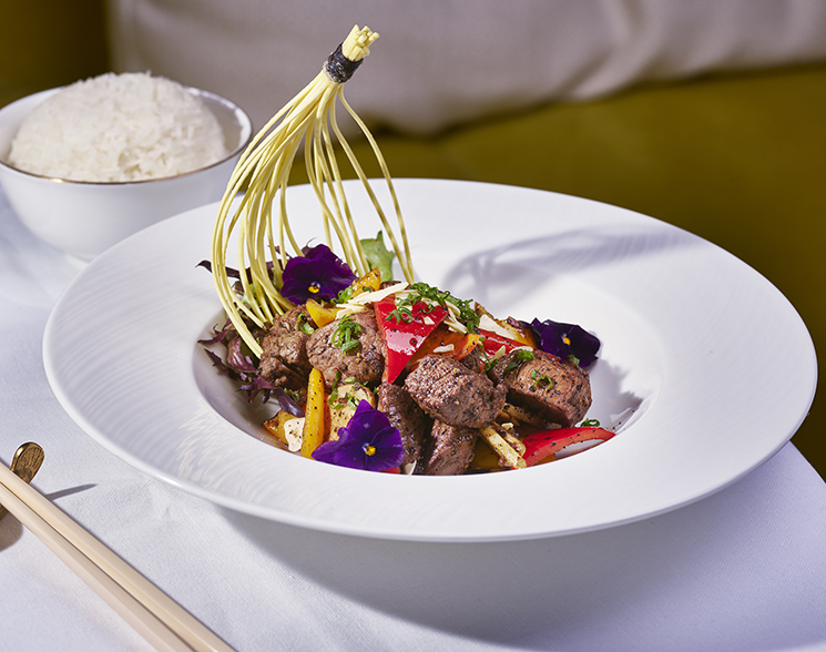 Meat and vegetables on a white plate with rice from Chyna Club restaurant