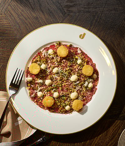 Plate of food on a white plate on top of a wooden table from Don's Prime