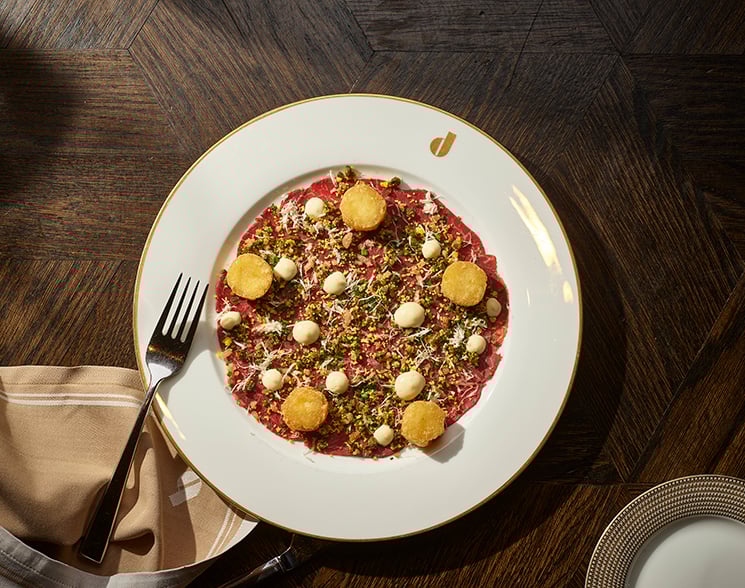 Plate of food on a white plate on top of a wooden table from Don's Prime